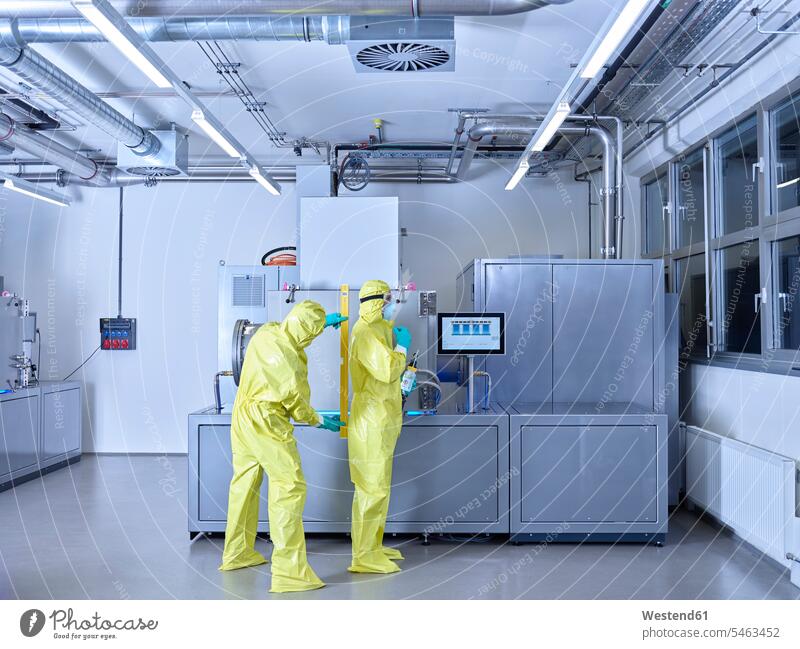 Chemists working in industrial laboratory, wearing protective clothing in the clean room Chemical Laboratory chemist Protective Suit At Work natural scientist