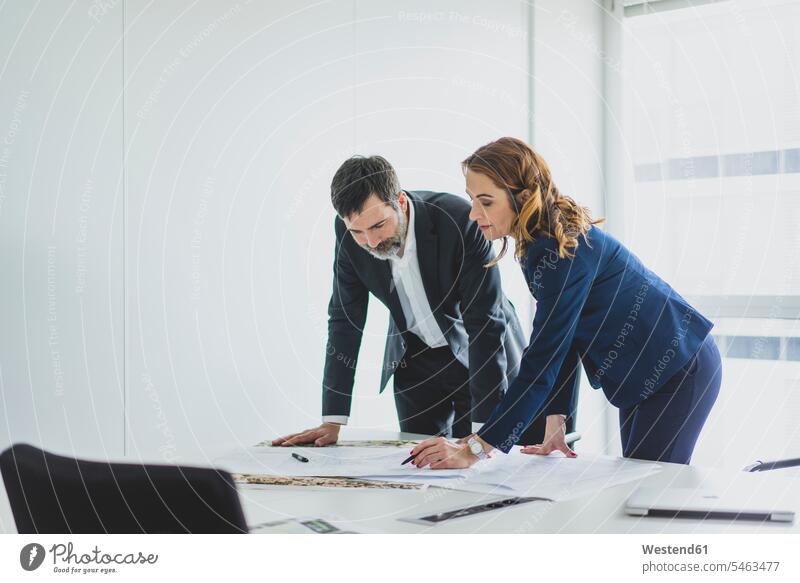 Businesswoman and businessman working on plan on desk in office business life business world business person businesspeople associate associates