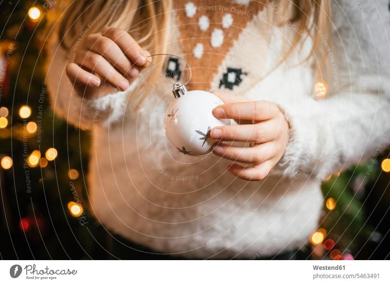 Decorating the christmas tree, girl holding a white bauble with silver stars human human being human beings humans person persons caucasian appearance