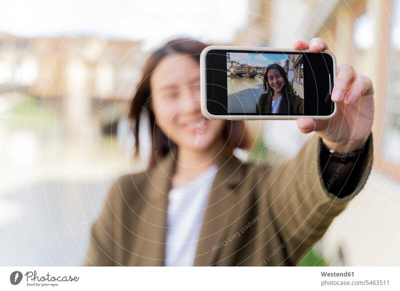 Italy, Florence, young tourist woman taking a selfie at Ponte Vecchio focus on foreground Focus In The Foreground focus on the foreground sharing share