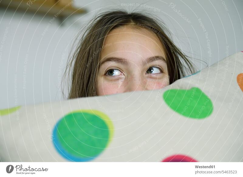 Girl hiding behind cushion cushions girl females girls portrait portraits hide child children kid kids people persons human being humans human beings Hide