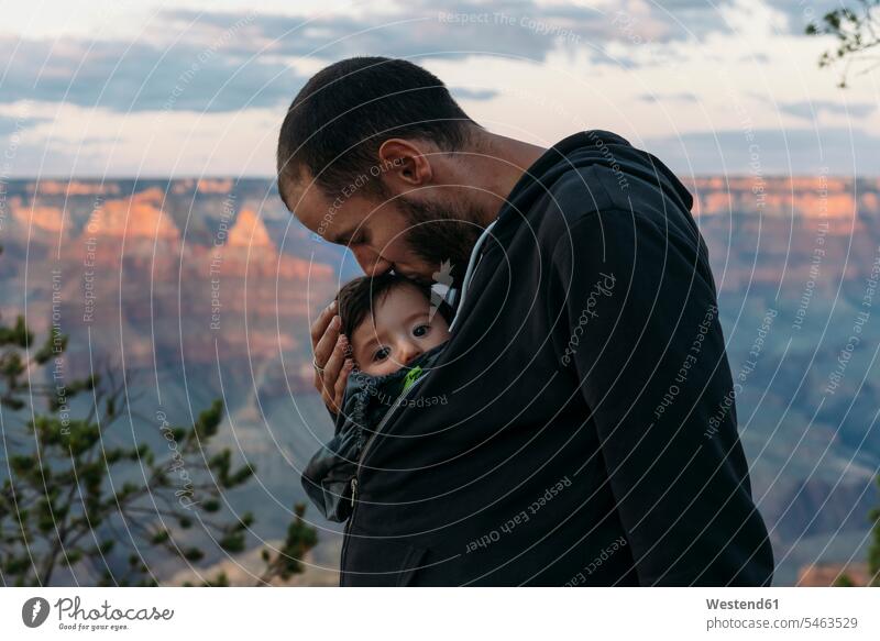 USA, Arizona, Grand Canyon National Park, father kissing baby girl at sunset kisses sunsets sundown pa fathers daddy dads papa infants nurselings babies
