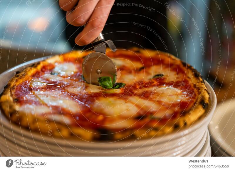 Cutting a pizza on a stack of plates cutting stacked stacks kitchen Pizza Pizzas Plate dish dishes Plates Arrangement Positioning Positionings Arrangements Food
