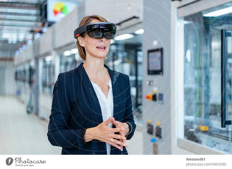 Businesswoman wearing AR glasses in a modern factory human human being human beings humans person persons caucasian appearance caucasian ethnicity european 1