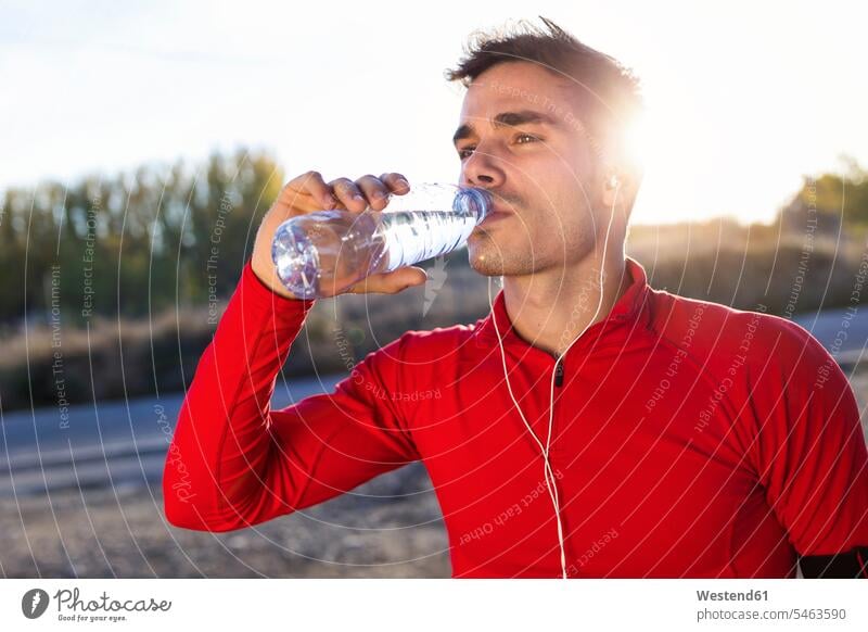 Young jogger drinking from a water bottle human human being human beings humans person persons caucasian appearance caucasian ethnicity european 1