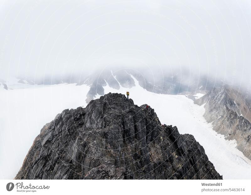 Greenland, Sermersooq, Kulusuk, Schweizerland Alps, two mountaineers reaching summit mountaintops summits mountain top snow climber alpinists climbers