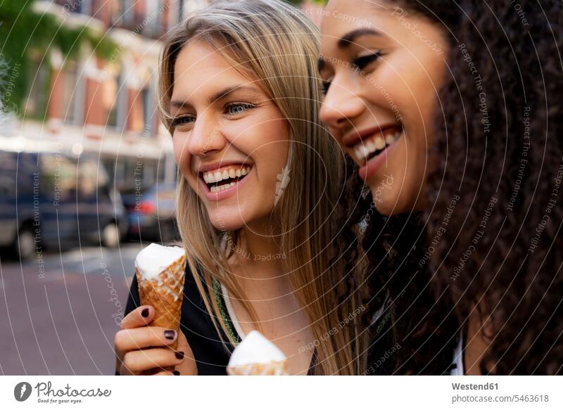 Two laughing girlfriends having fun, eating ice cream female friends icecream Ice Creams ice-cream City Break City Trip Urban Tourism journey travelling
