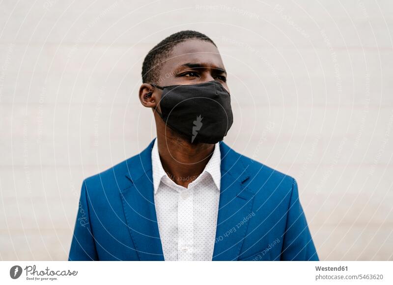 Male professional wearing protective face mask against wall during COVID-19 pandemic color image colour image Spain outdoors location shots outdoor shot