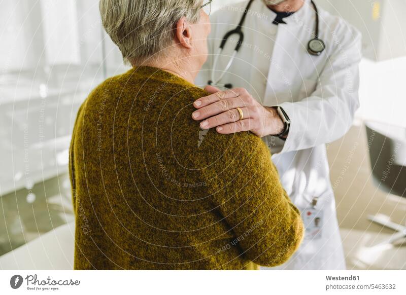 Doctor holding shoulder of senior patient in his practice health healthcare Healthcare And Medicines medical medicine disease diseases ill illnesses sick