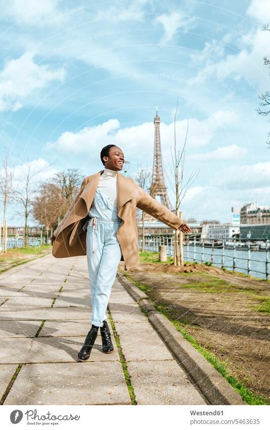 France, Paris, Happy woman walking at the riverside with the Eiffel tower in the background riverbank happiness happy females women female tourist Eiffel Tower