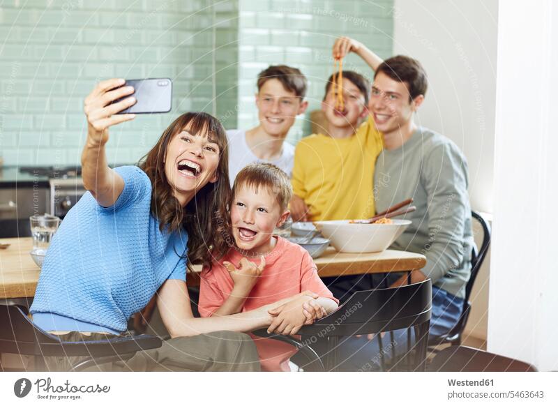 Mother and her four sons taking smartphone selfies at lunch at home indoor indoor shot indoor shots interior interior view Interiors human human being