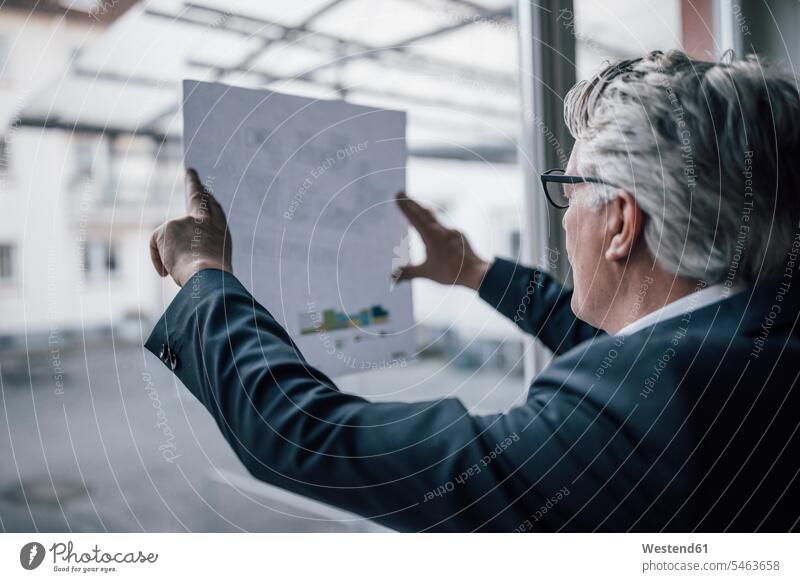Senior businessman looking at paper at the window Occupation Work job jobs profession professional occupation architects business life business world