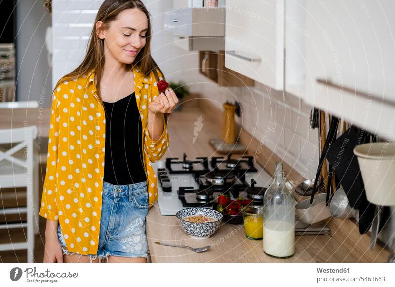 Young woman having breakfast in kitchen at home human human being human beings humans person persons celibate celibates singles solitary people solitary person