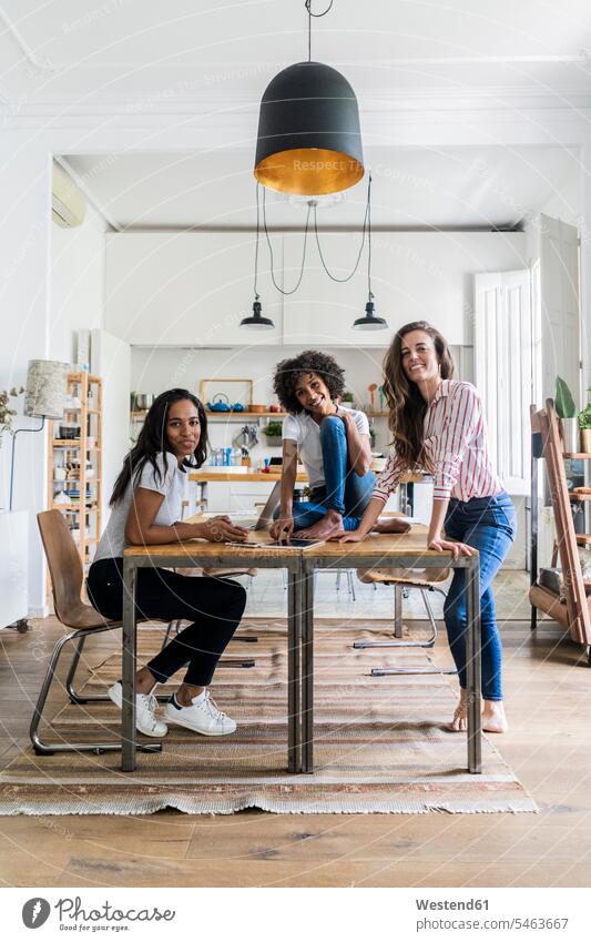 Portrait of three happy women at table at home portrait portraits woman females smiling smile female friends Table Tables Adults grown-ups grownups adult people