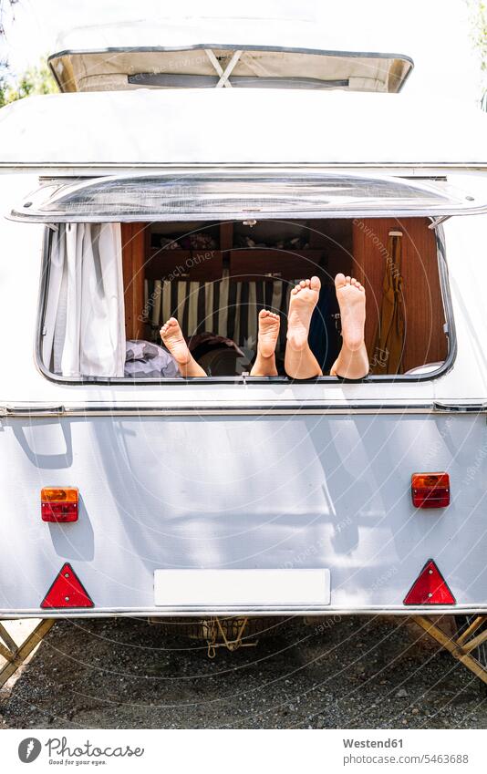 Sisters resting feet on window of motor home color image colour image Spain leisure activity leisure activities free time leisure time casual clothing