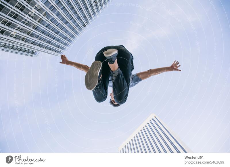 Young man performing parkour against sky in city color image colour image Spain leisure activity leisure activities free time leisure time casual clothing