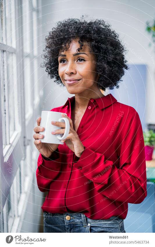 Smiling woman with cup of coffee looking out of window at home Coffee Coffee Cup Coffee Cups smiling smile females women view seeing viewing windows Drink