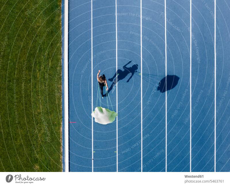 Top view of female runner with parachute on tartan track human human being human beings humans person persons caucasian appearance caucasian ethnicity european