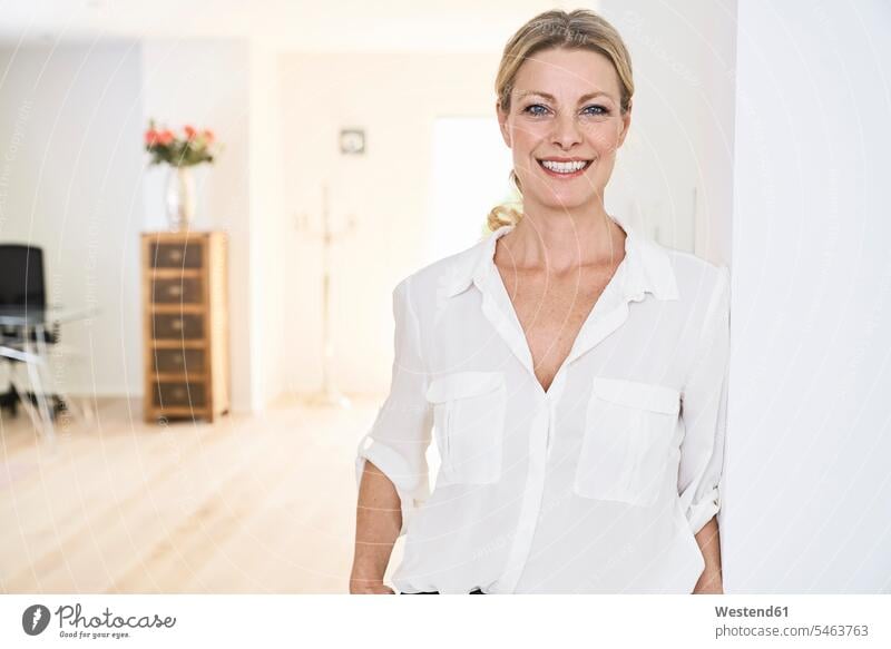 Portrait of smiling woman wearing white blouse at home blouses smile females women portrait portraits Adults grown-ups grownups adult people persons human being