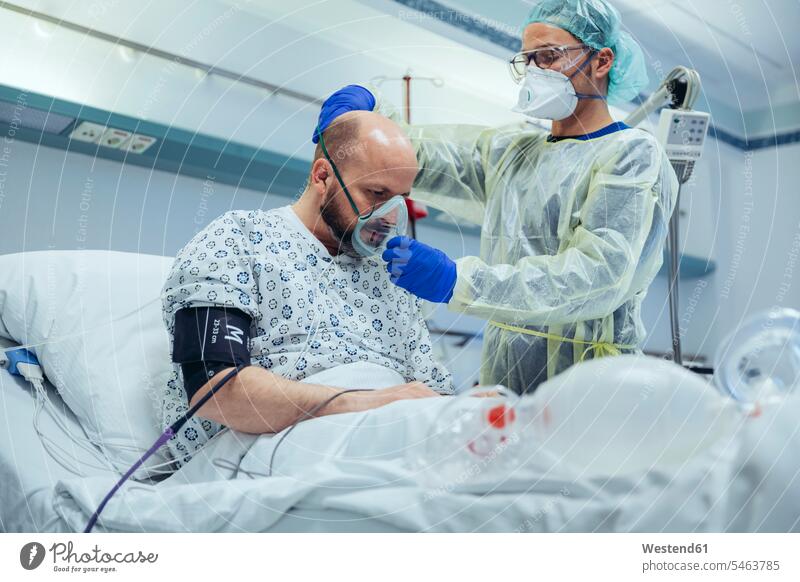 Doctor giving artificial respiration to patient in emergency care unit of a hospital human human being human beings humans person persons caucasian appearance