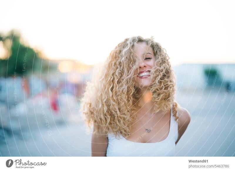 Portrait of happy young woman with blond ringlets portrait portraits females women blond hair blonde hair happiness Adults grown-ups grownups adult people