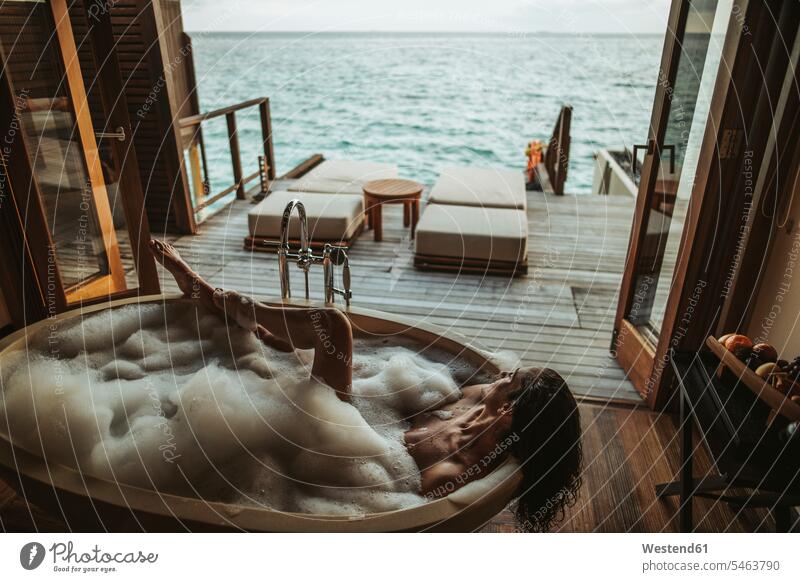 Woman relaxing in bathtub with view to the sea, Maguhdhuvaa Island, Gaafu Dhaalu Atoll, Maldives bath tub bath tubs bathtubs bathe Taking A Bath relaxation