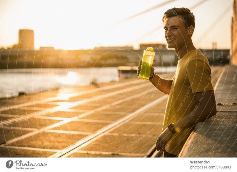 Man with water bottle after workout against clear sky color image colour image outdoors location shots outdoor shot outdoor shots Sportswear Sports Wear