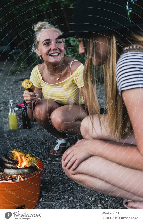 Two happy young women having a barbecue barbecueing Barbecuing grilling together Barbecue BBQ Barbeque female friends woman females Party Parties Celebration