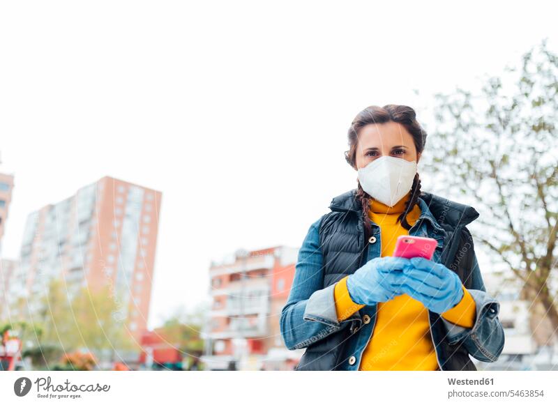 Woman wearing protective mask and using smartphone in the city telecommunication phones telephone telephones cell phone cell phones Cellphone mobile