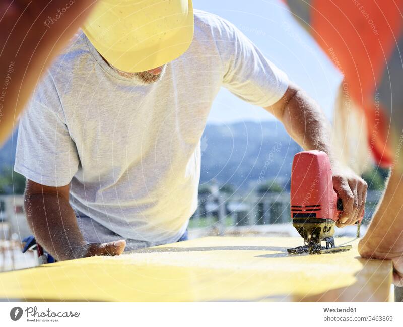 Construction worker cutting plywood with jigsaw on construction site Jigsaw construction worker builders Building Site sites Building Sites construction sites