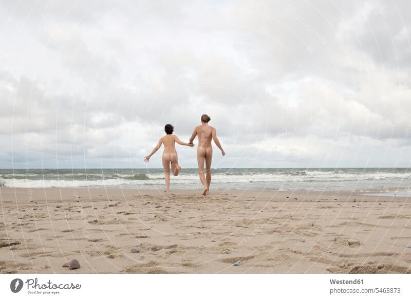 Nude couple running to the sea, holding hands Emotions Feeling Feelings Sentiment Sentiments loving aspirations Crave Craving longing wistful yearning free