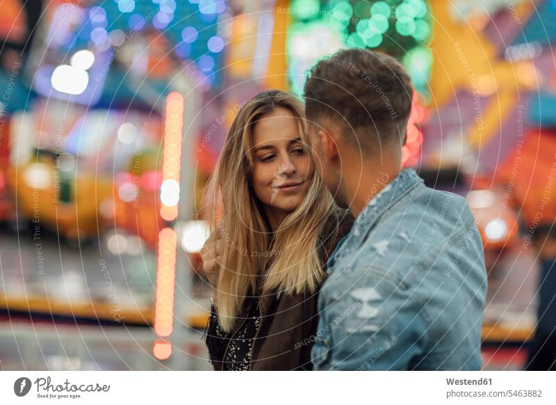 Young couple in love, embracing at a funfair funfairs kermis fairground fun fair fairgrounds fun fairs kissing kisses young couple young couples young twosome