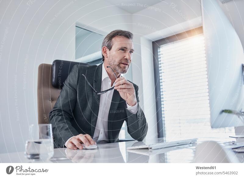 Businessman working at desk in office Business man Businessmen Business men offices office room office rooms desks At Work business people businesspeople