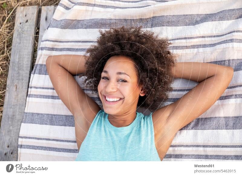Portrait of happy woman lying on a blanket outdoors Blanket Blankets smiling smile happiness portrait portraits laying down lie lying down females women Adults