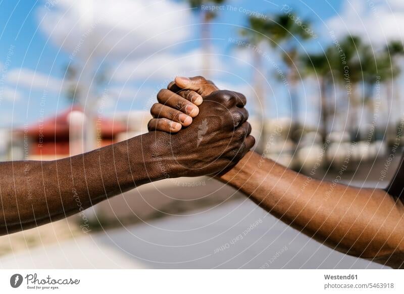 Young men shaking hands on outdoor basketball court human human being human beings humans person persons African black black ethnicity coloured 2 2 people