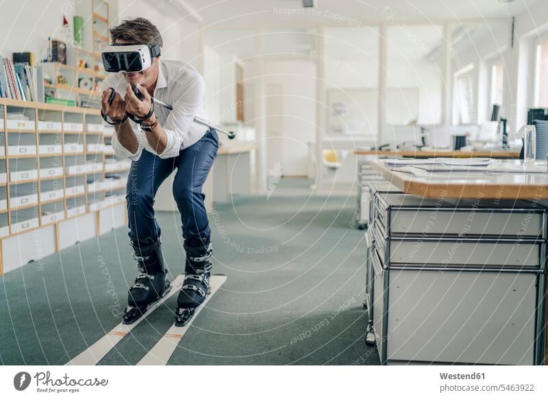 Businessman skiing in office, using VR glasses skis vacation Holidays playing skier skiers Business man Businessmen Business men Virtual Reality