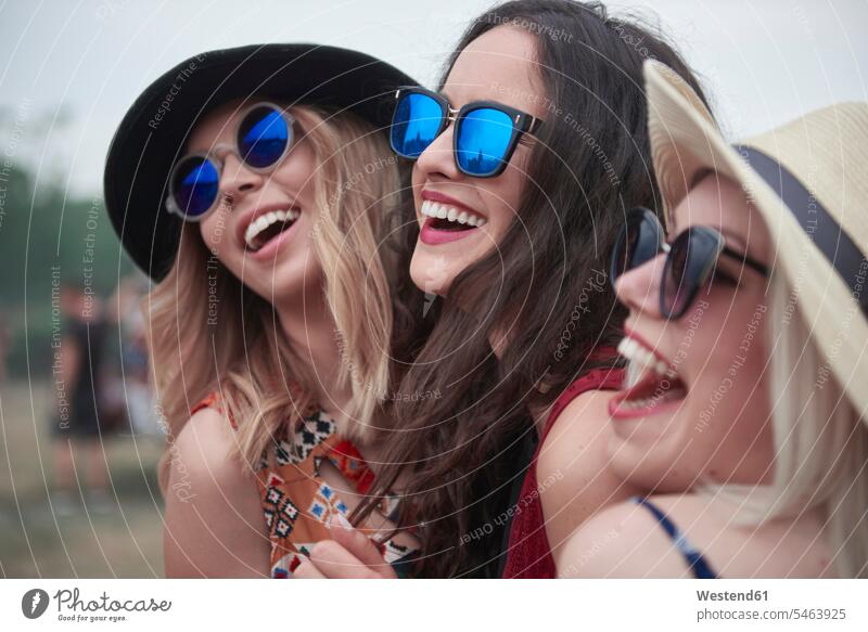 Happy girls at the music festival music festivals sunglasses sun glasses Pair Of Sunglasses female friends woman females women happiness happy celebrating