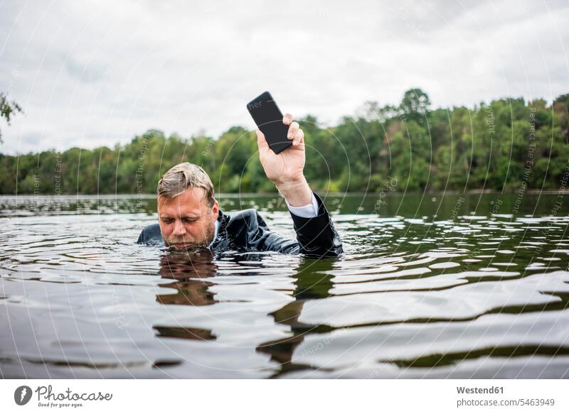 Businessman holding cell phone inside a lake business life business world business person businesspeople Business man Business men Businessmen telecommunication