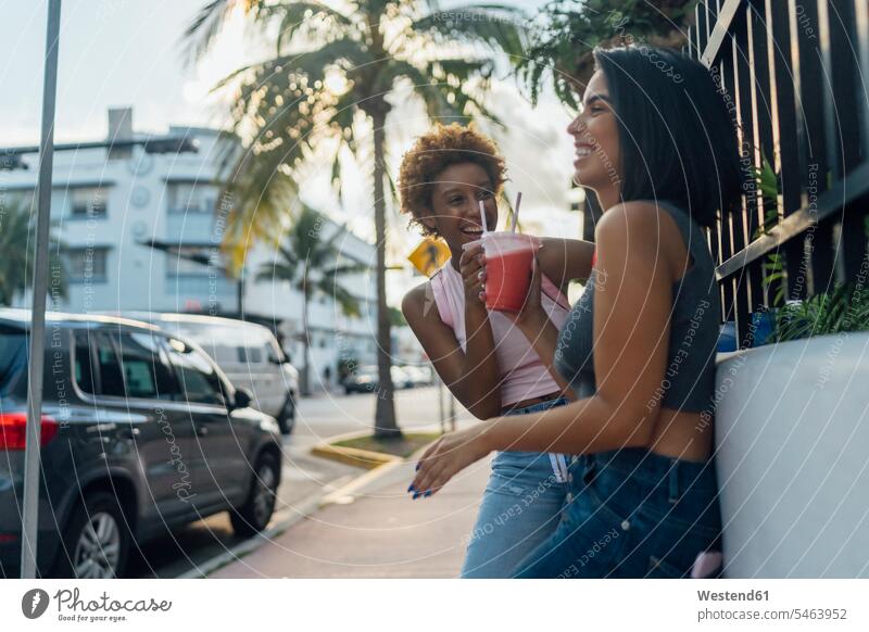 USA, Florida, Miami Beach, two happy female friends having a soft drink in the city refreshing drink soft drinks refreshing drinks town cities towns happiness