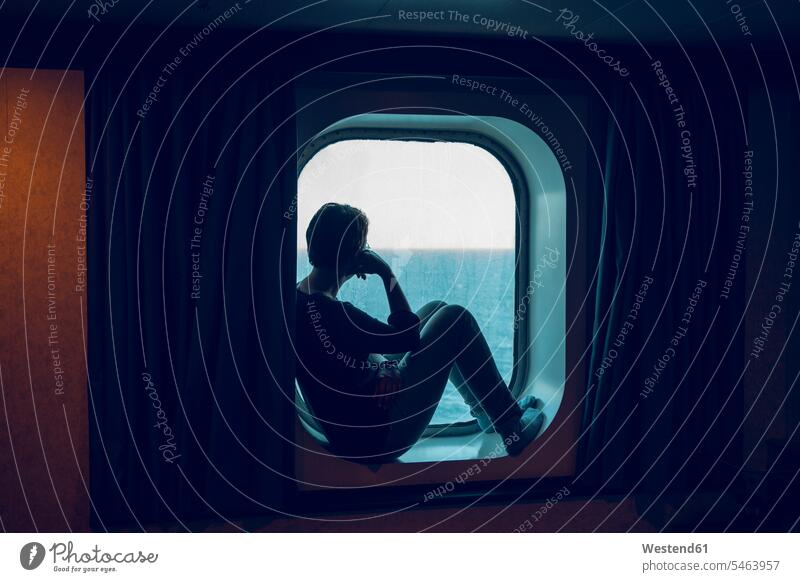 Woman looking at view while sitting at ship window color image colour image indoors indoor shot indoor shots interior interior view Interiors day daylight shot