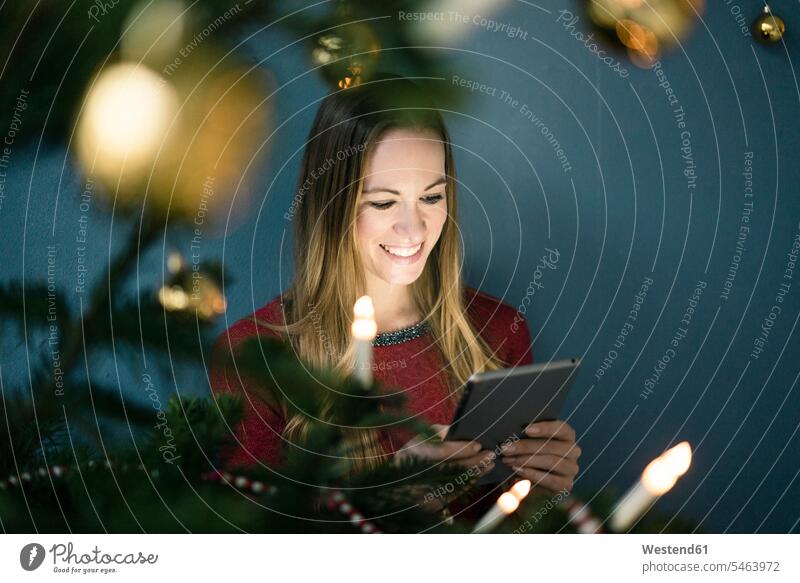 Portrait of smiling woman using tablet at Christmas time females women digitizer Tablet Computer Tablet PC Tablet Computers iPad Digital Tablet digital tablets