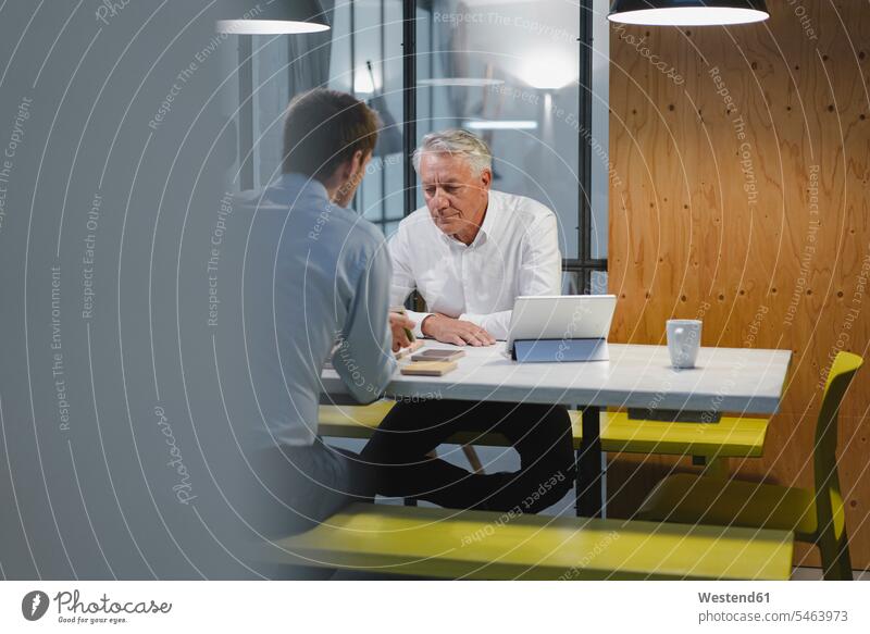 Two businessmen sitting in office, working together Occupation Work job jobs profession professional occupation business life business world business person