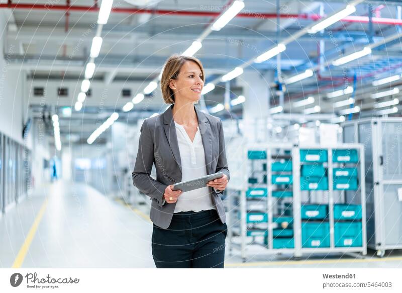 Smiling businesswoman with tablet in a modern factory human human being human beings humans person persons caucasian appearance caucasian ethnicity european 1