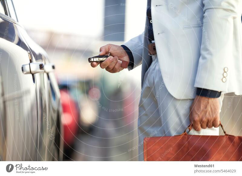 Businessman unlocking his car, close up Business man Businessmen Business men car key car keys automobile Auto cars motorcars Automobiles on the move on the way