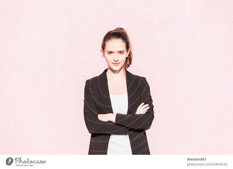 Portrait of confident young woman in front of pink wall portrait portraits females women Rosy confidence walls Adults grown-ups grownups adult people persons