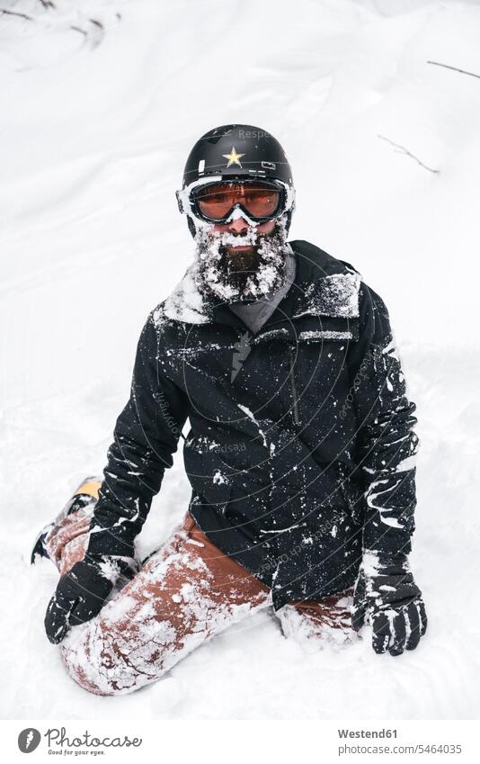Snow-covered young man in skiwear kneeling in snow snow-covered snow covered covered in snow snowy Skiwear ski suits Ski-Wear Ski Wear Kneeing men males skiing