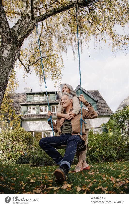 Happy woman embracing senior man on a swing in garden playground swing Swing - Play Equipment swing set swings swingset relax relaxing smile embrace Embracement