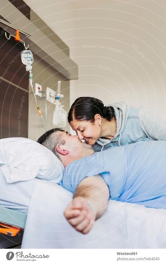 Affectionate woman visiting husband lying in hospital bed human human being human beings humans person persons caucasian appearance caucasian ethnicity european