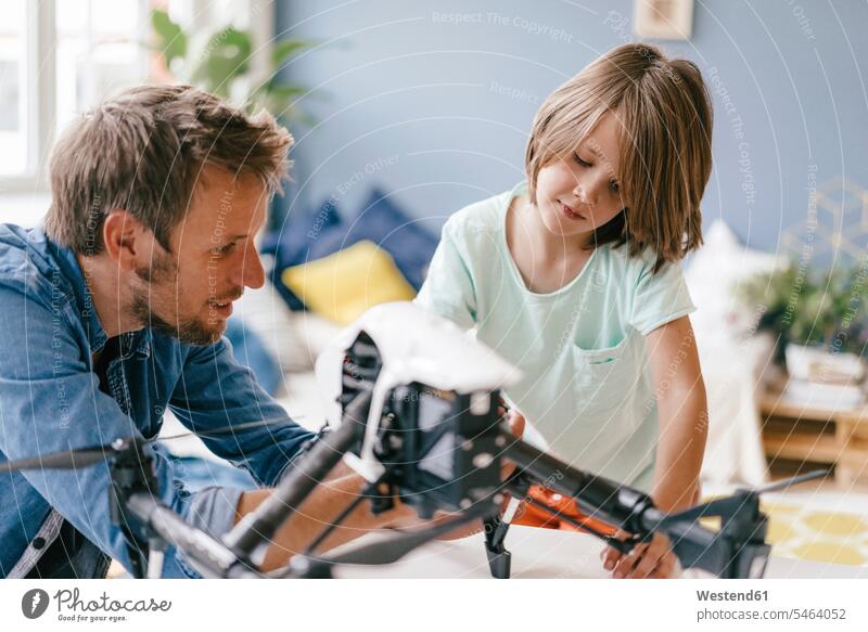 Father and son with drone at home drones father pa fathers daddy dads papa sons manchild manchildren together parents family families people persons human being