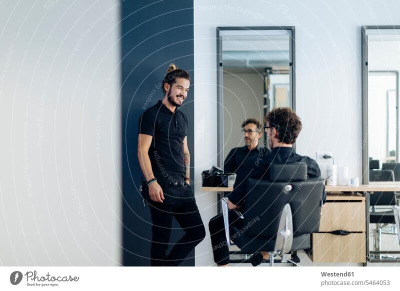 Happy male barbers talking in hair salon color image colour image indoors indoor shot indoor shots interior interior view Interiors day daylight shot